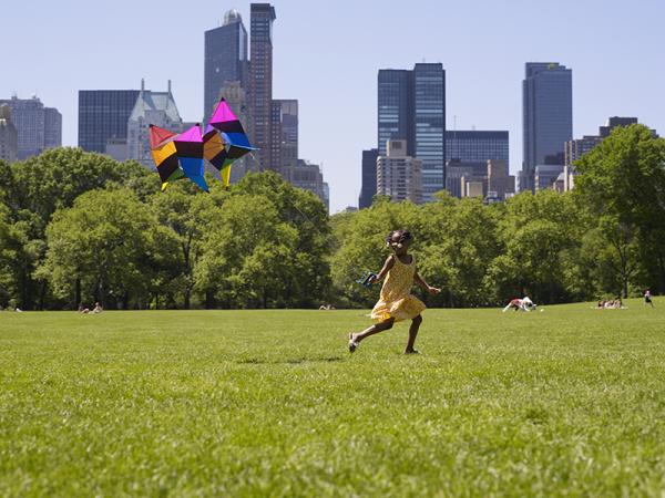 Girl running in a field with a kite